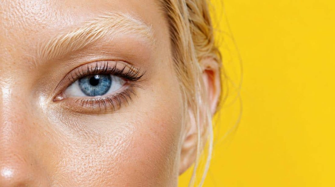 Close-up of a lightened eyebrow and blue eye