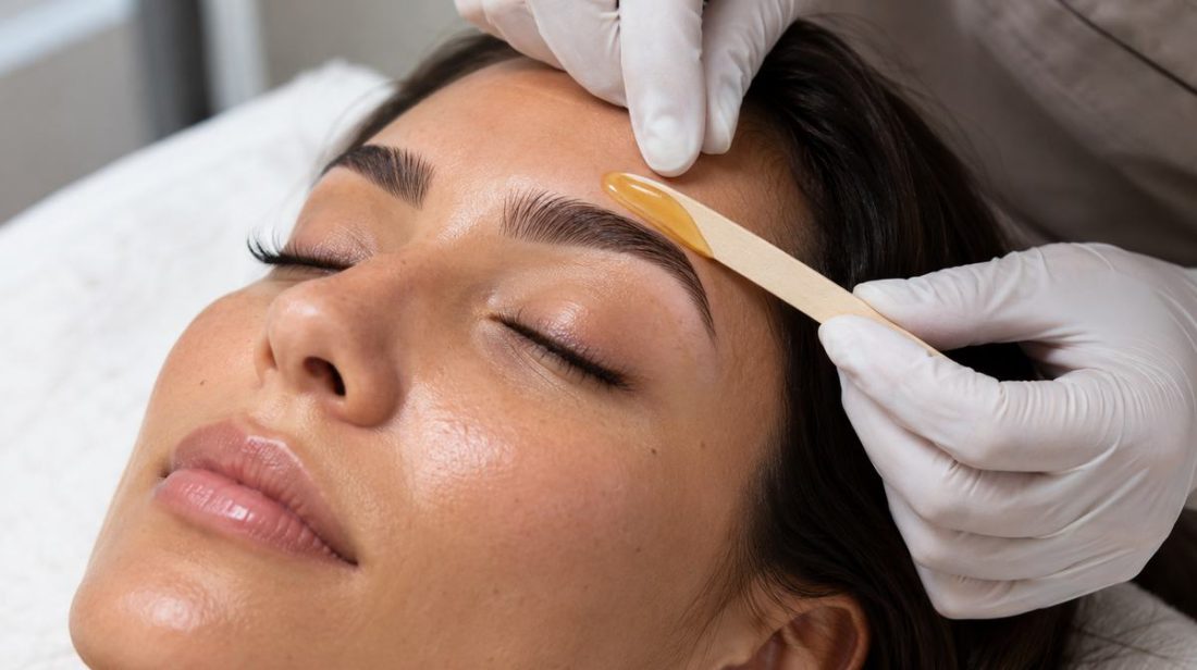 Esthetician waxing a client's brows