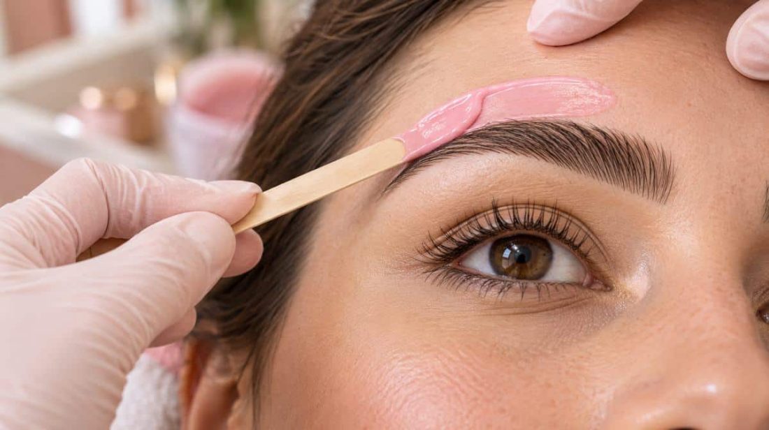 Soft pink wax applied along the brow with a wooden stick