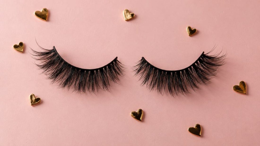False lashes and small gold hearts on pink