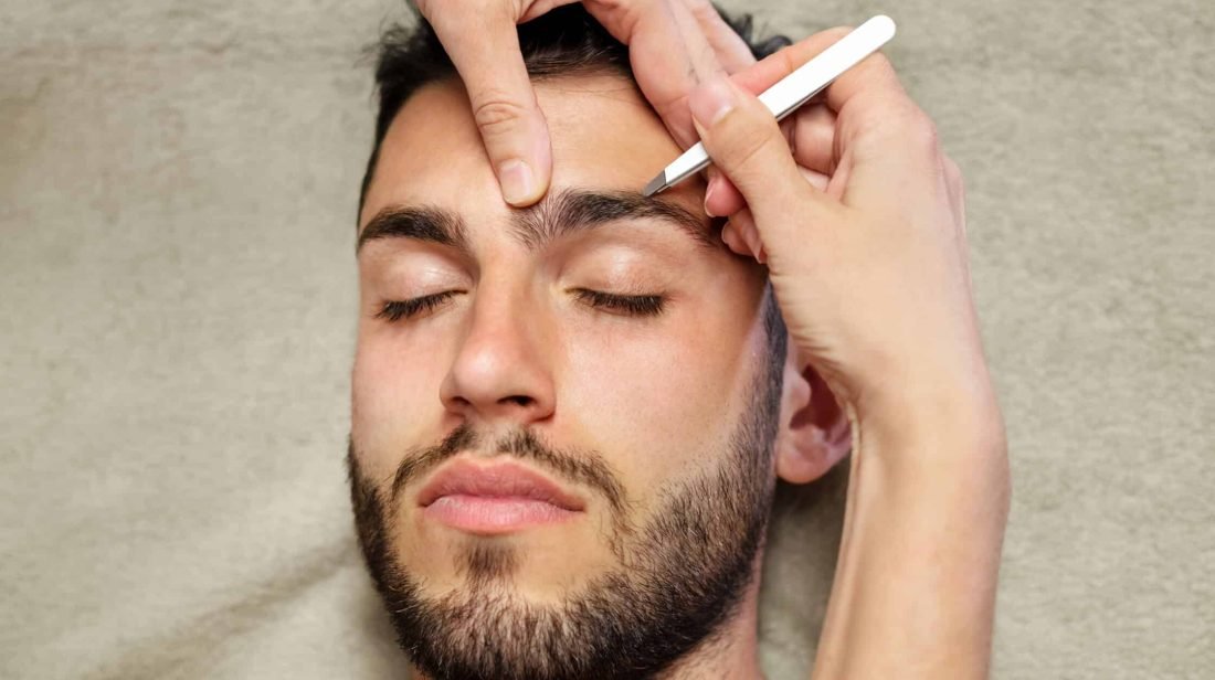 man getting eyebrows groomed and tweezed