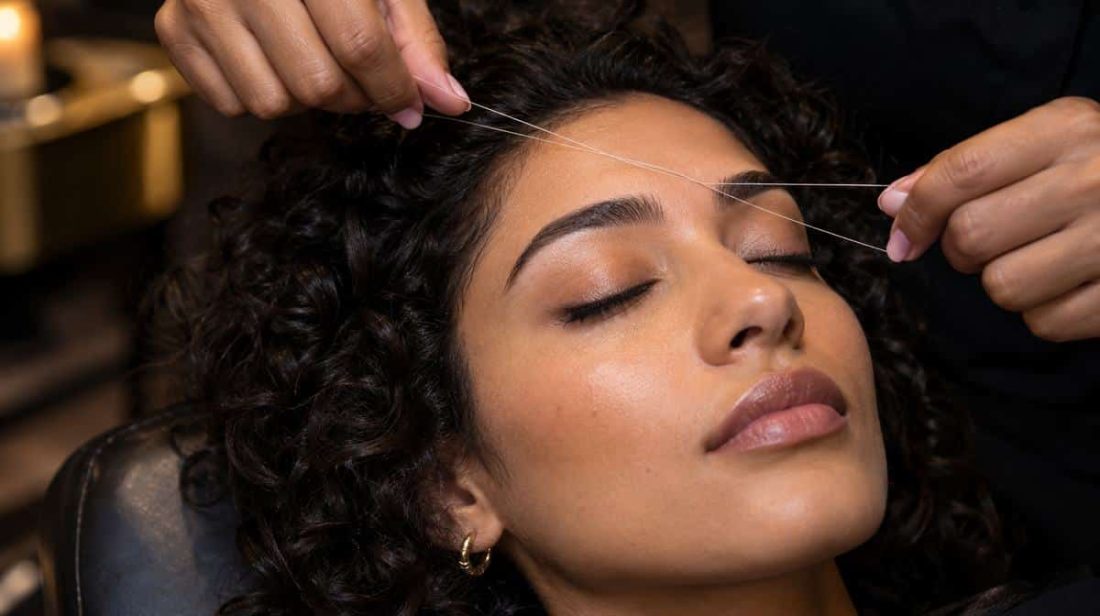 Woman with curly hair getting her brows threaded